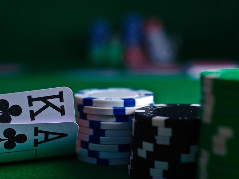 Close-up of two playing cards and stacks of poker chips on a green felt table